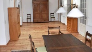 A dining area with a wooden table and chairs, a large wooden cabinet, and a skylight above. - Holiday Apartment in Flieth-stegelitz (Flieth-Stegelitz)
