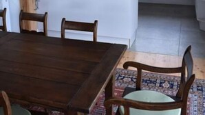 A modern kitchen with white cabinets, a wooden island, and a dining area with a table and chairs. - Holiday Apartment in Flieth-stegelitz (Flieth-Stegelitz)