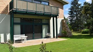 A modern house with a balcony, a stone feature, and a well-maintained lawn. - Holiday Apartment in Flieth-stegelitz (Flieth-Stegelitz)