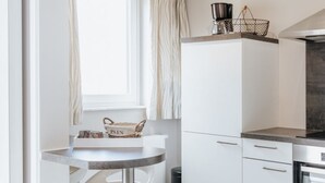 Una cocina moderna con armarios blancos, una mesa redonda y una encimera.