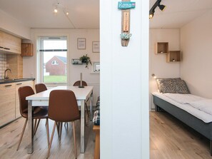 A modern, compact living space with a dining area, kitchenette, and a cozy sleeping area. - 4 Star Holiday Home in Romo (Rømø)