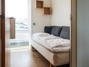 Um quarto com uma cama, uma janela e uma porta.
