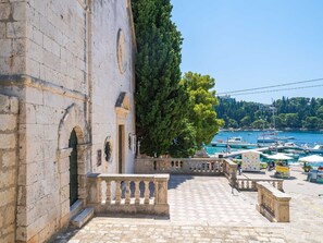 A stone building with a balcony overlooking a marina with boats. - Apartments Villa Royale - Luxury One Bedroom Apartment With Terrace (Konavle)