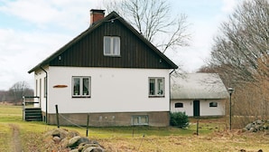 A two-story house with a white exterior and dark roof. - 9 Person Holiday Home in Bastad (Bastad)