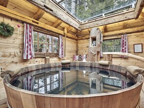 A wooden cabin with a large wooden hot tub, wooden walls, and a skylight. - at Haldensee Modern Retreat (Graen)