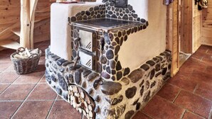 Un interior rústico de madera con chimenea de piedra, una escalera de madera y una decoración de estilo rústico.
