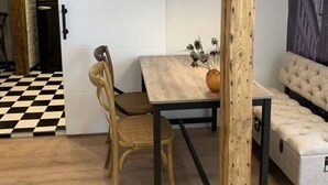 A cozy dining area with a wooden table, chairs, and a bench. A wall-mounted sign reads "COOKING." - Cathedral Whispers Modern Retreat (Schwerin)