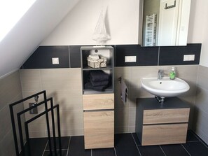 Une salle de bain moderne avec un puits de lumière, un lavabo et un miroir.