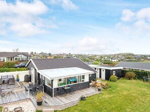 A modern house with a large deck, a swimming pool, and a well-maintained lawn. - 4 Person Holiday Home in Hejls (Hejls)