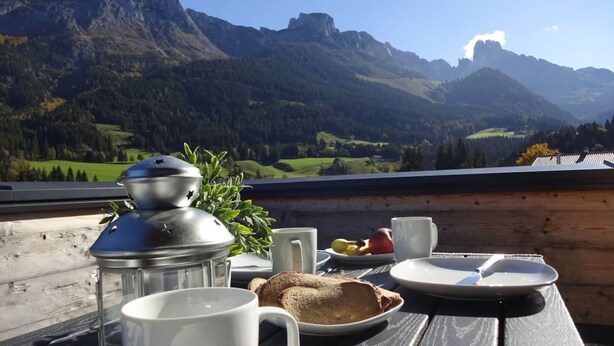 A wooden table with breakfast items and a view of mountains. - Huttenzauber 4 Comfortable Holiday Residence (Annaberg-Lungoetz)