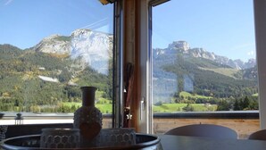 A table with a decorative bowl and a vase, a window with a mountain view, and a timestamp indicating April 1, 2014. - Huttenzauber 4 Comfortable Holiday Residence (Annaberg-Lungoetz)