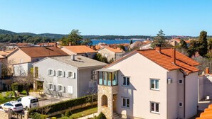 Ett bostadsområde med hus som har röda tegeltak och en fri utsikt över en vattenyta i fjärran.