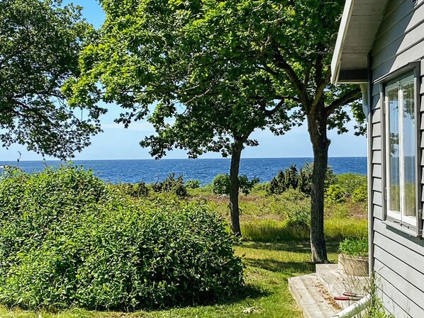 A coastal property with a view of the sea, a well-maintained garden, and a wooden deck. - 4 Star Holiday Home in Sturko (Sturkö)