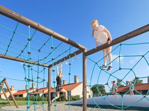 Un parque infantil con una estructura de red y vigas de madera.
