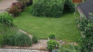 A well-maintained garden with a variety of plants and a small wooden structure. - Alte Kaeserei Comfortable Holiday Residence (Grimma)
