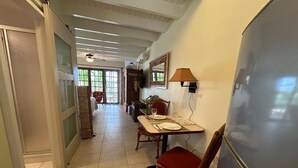 A dining area with a table set for two, chairs, a refrigerator, and a lamp. - Paradera Palms Apt. 1 (Paradera)
