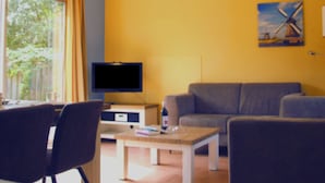 A living room with a television, a sofa, and a table. - Cozy Family Bunglow in Zevenhuizen (Zevenhuizen)