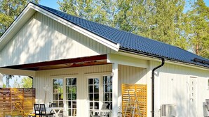 A single-story building with a covered patio area, large windows, and a metal roof. - 4 Star Holiday Home in Kopingsvik (Kopingsvik)