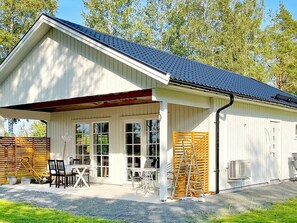 A single-story building with a covered porch, large windows, and a metal roof. - 4 Star Holiday Home in Kopingsvik (Kopingsvik)
