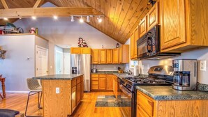 Una cocina moderna con armarios de madera, electrodomésticos de acero inoxidable y una isla central.