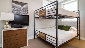 A bunk bed with a television on a wooden dresser, a painting on the wall, and a window with blinds. - Beautiful Unit CHI in Prime River North - 2 (Chicago)