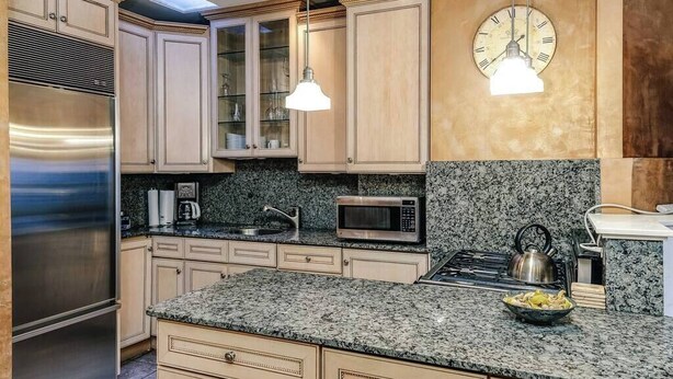 A modern kitchen with granite countertops, stainless steel appliances, and light wood cabinetry. - Historic and Unique Brownstone in Gold Coast - 3 (Chicago)
