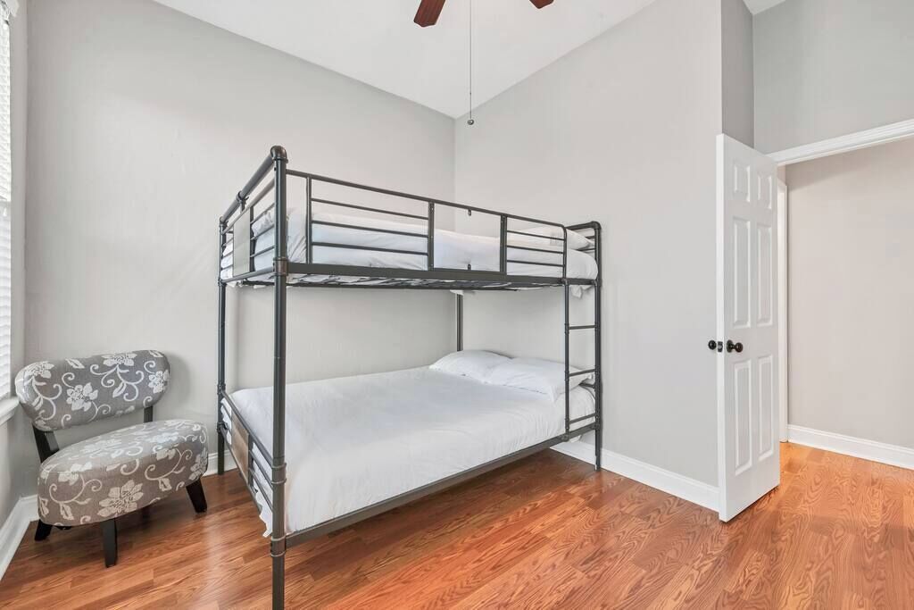 A bunk bed room with a chair and a door.