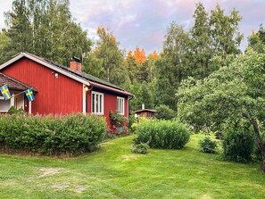 A red building with a small garden and a pathway leading to it. - 2 Person Holiday Home in Aby (Aby)