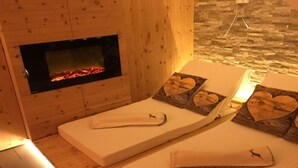 A spa room with two massage beds, each with heart-shaped pillows and a towel. - Chalet Bernegg - Otztal (Sautens)