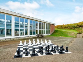 A chessboard set up on a paved area with a building in the background.