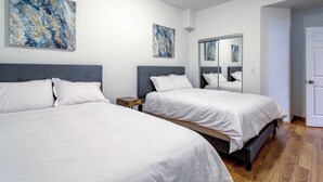 A hotel room with two beds, a small bedside table, a large mirror, and abstract artwork on the walls. - Downtown Goose Island with access to patio - 1 (Chicago)