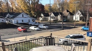 A wooden deck with a round table and chairs, surrounded by a metal railing. - Close to Downtown - 2 queen beds (Springfield)
