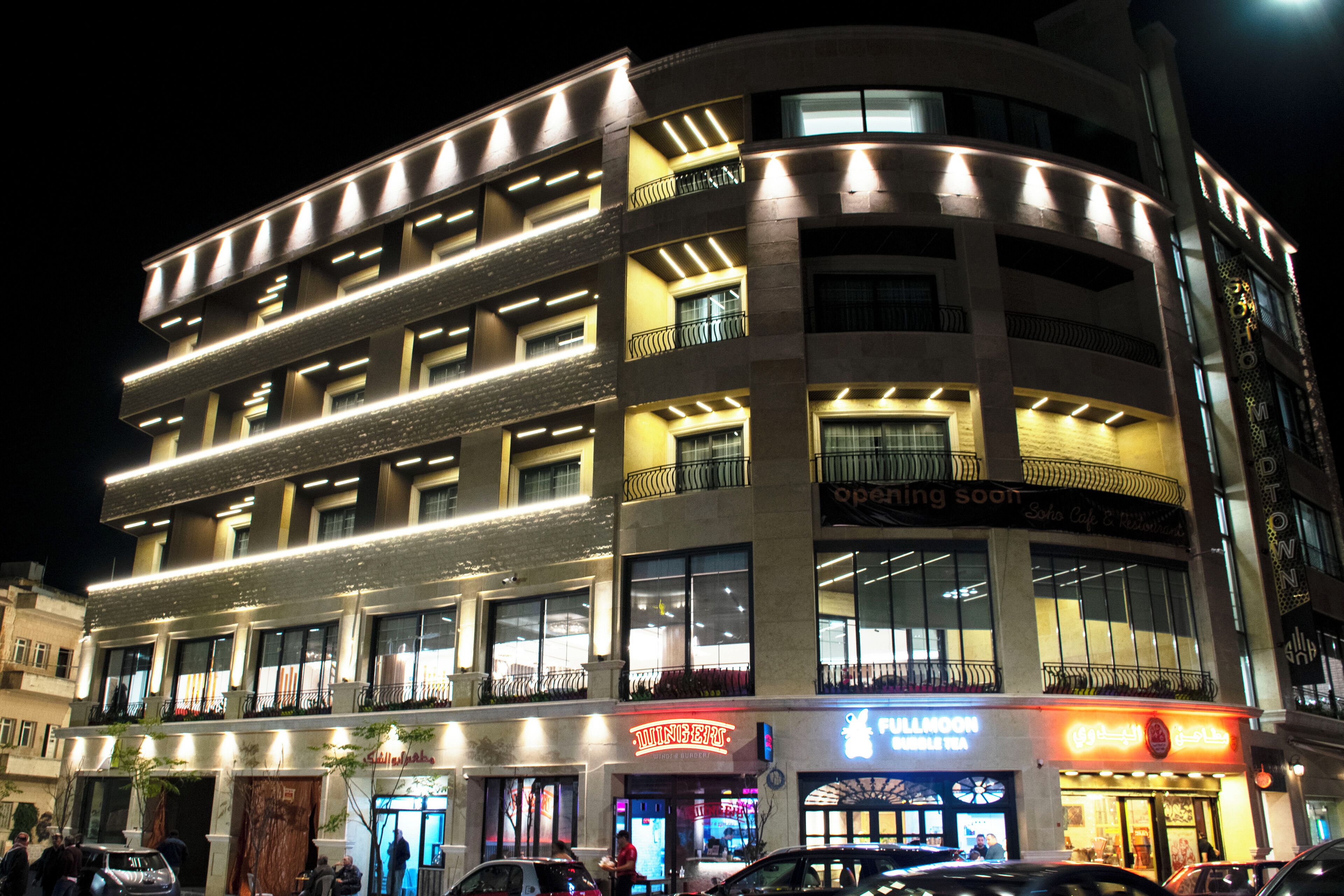 A multi-story hotel with balconies, a ground-level restaurant, and a visible storefront.