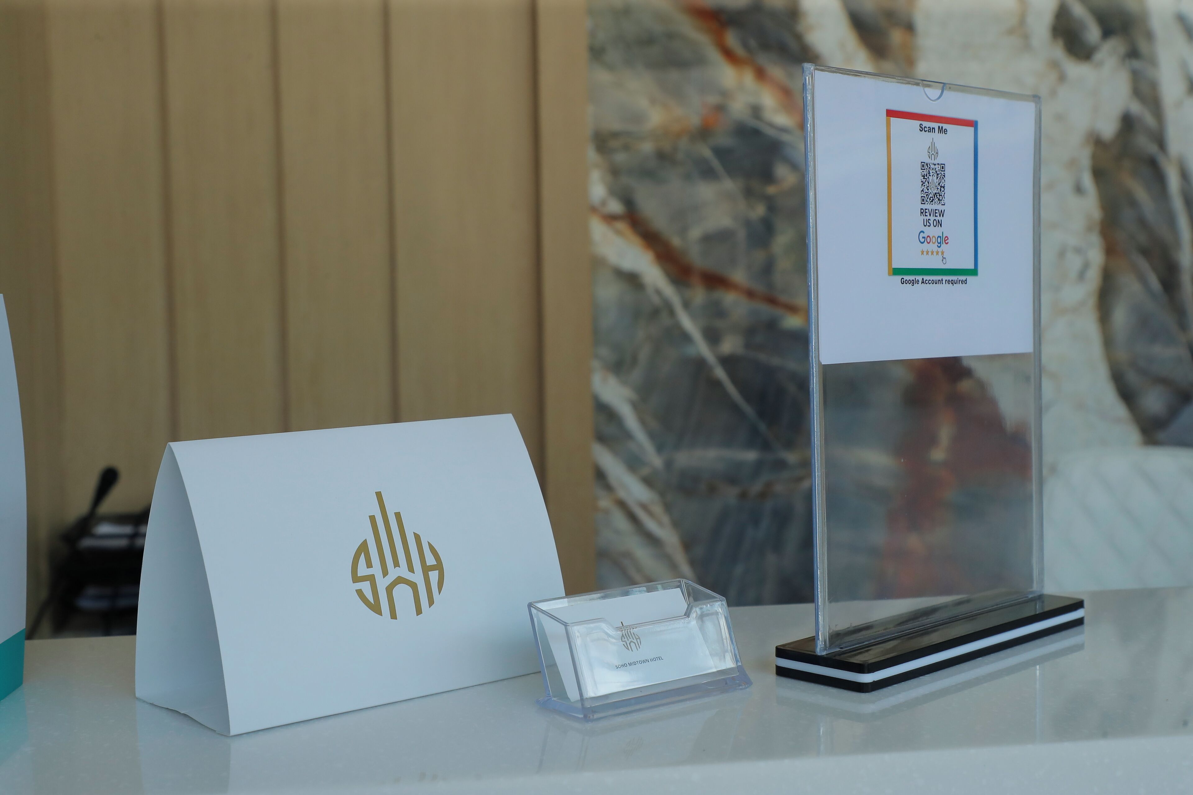 Un taulell de recepció amb una targeta blanca que mostra un codi QR i un senyal que indica que es necessita un compte Google.