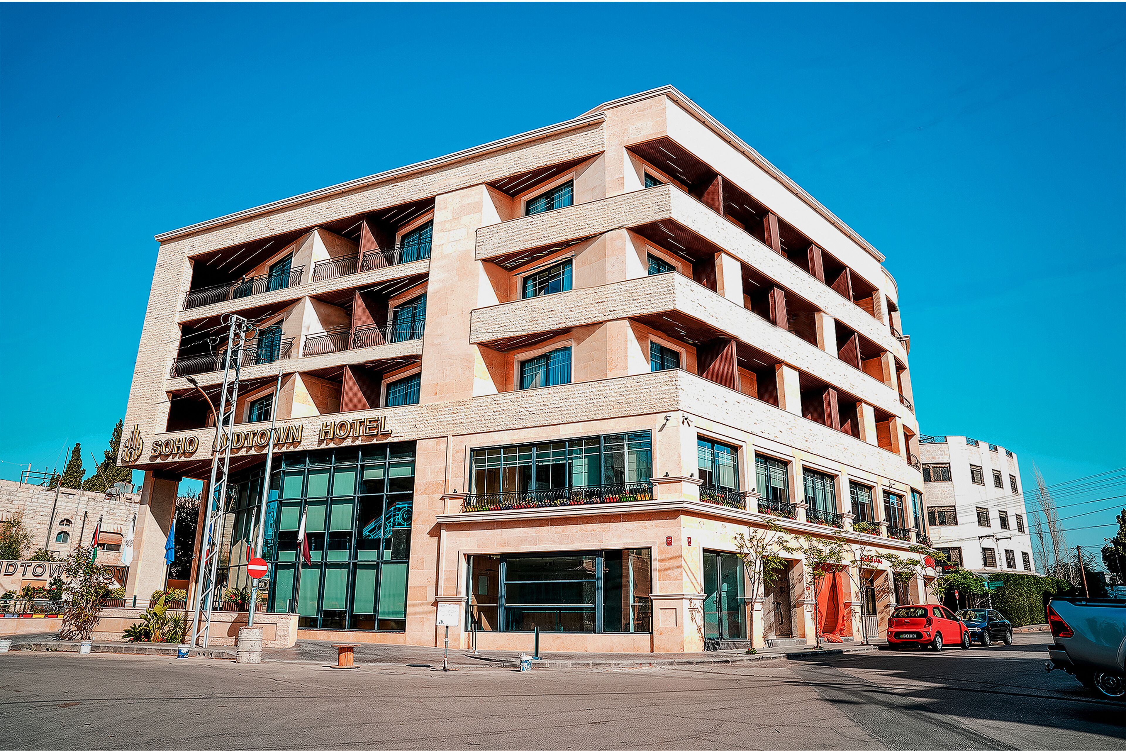 A multi-story hotel with a modern architectural design, featuring balconies and large windows.