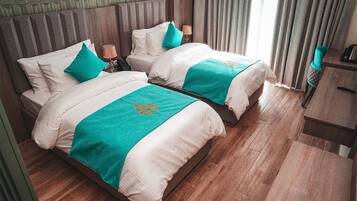 Ein Hotelzimmer mit zwei Betten, Holzboden, einem gemusterten Wandbild und Blick ins Freie.