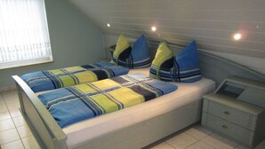 A bedroom with a bed, pillows, a nightstand, and a window. - Also a Modern Retreat (Röbel/Müritz)