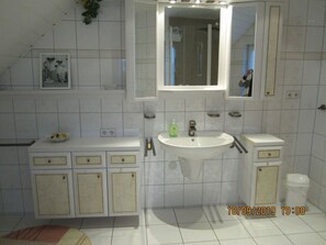A bathroom with a sink, mirror, cabinets, and a shower area. - Also a Modern Retreat (Röbel/Müritz)