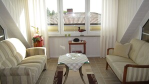 A cozy room with two sofas, a small table, and a window with curtains. - Also a Modern Retreat (Röbel/Müritz)