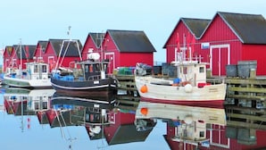 A row of red buildings with boats docked in front. - Apartment Near the Beach With sun Balcony (Boltenhagen)