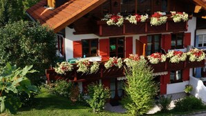 A traditional chalet with a sloped roof, wooden balconies with flower boxes, and a well-maintained garden. - Bader Modern Retreat (Blaichach)