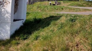 A large, historic building with a prominent arched entrance, situated on a grassy hill with a clear sky. - Vakantiehuis Mosella (Oberfell)