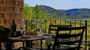 A terrace with a view of a hill and a distant building. - Aurora Comfortable Holiday Residence (Oprtalj)