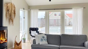 A modern living room with a fireplace, grey sofa, and a coffee table. - 5 Star Holiday Home in Gotlands Tofta (Gotlands Tofta)