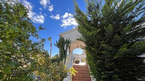 A staircase leading to a covered area with a white railing and a decorative balustrade. - Costa Blanca Poolside Bliss (Rojales)