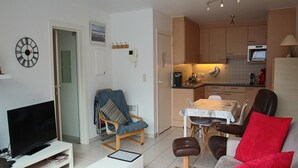 A modern living room with a TV, seating, and a dining area. - Apartment in Nieuwpoort Near the Beach (Nieuwpoort)