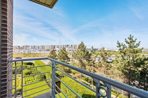 A balcony with a view of a cityscape, including high-rise buildings and a river. - Castle Apartment With View (Blankenberge)