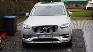 Ein silberner Volvo SUV steht auf einer Schotterauffahrt, im Vordergrund befindet sich eine dekorative Schwaneinskulptur.