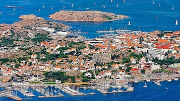 A coastal town with a marina, buildings with red roofs, and sailboats.