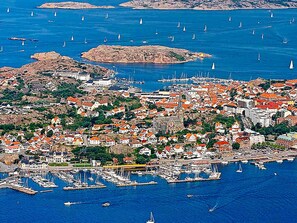 Eine Küstenstadt mit einem Hafen, roten Dächern und Segelbooten.